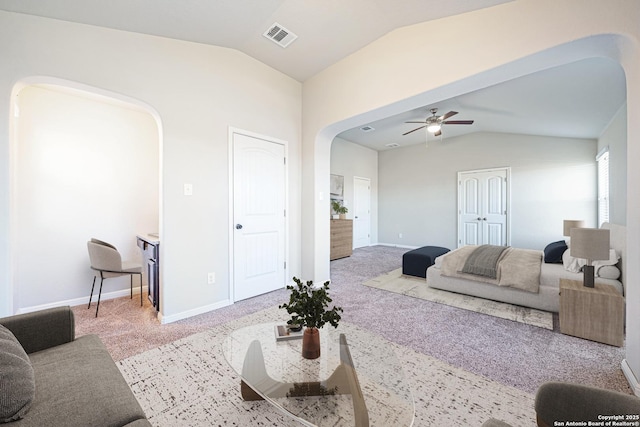 carpeted living room featuring arched walkways, visible vents, lofted ceiling, and baseboards