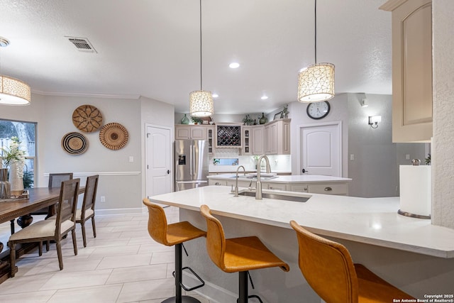 kitchen featuring light countertops, a sink, visible vents, and stainless steel fridge with ice dispenser