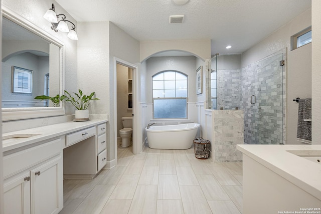 bathroom with visible vents, a soaking tub, a textured ceiling, vanity, and a shower stall