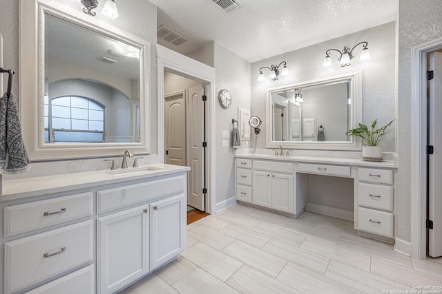 bathroom with two vanities, a sink, and visible vents