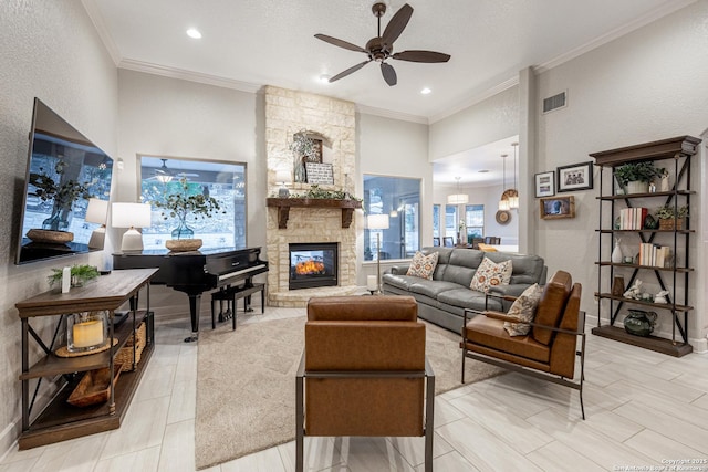 living room with ceiling fan, a stone fireplace, visible vents, and crown molding