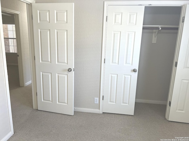 unfurnished bedroom with baseboards, a closet, and light colored carpet