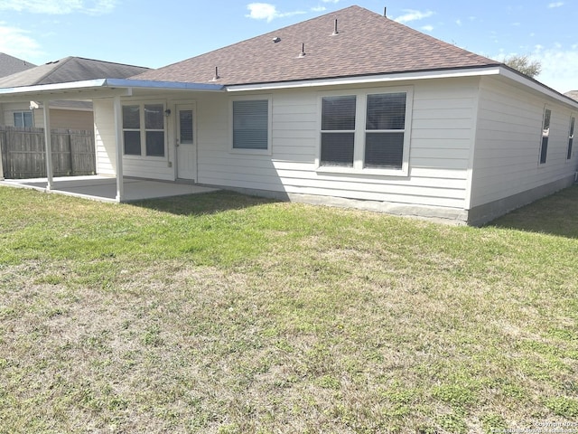 rear view of house with a yard, a patio, and fence