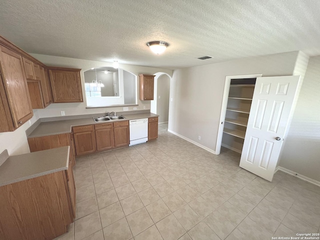 kitchen with arched walkways, visible vents, a sink, dishwasher, and baseboards