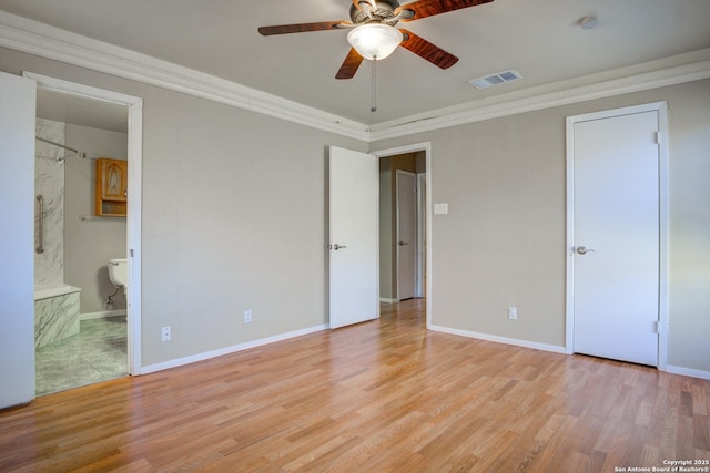 unfurnished bedroom featuring baseboards, crown molding, visible vents, and wood finished floors