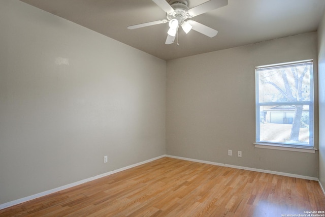 spare room with light wood-style floors, ceiling fan, and baseboards