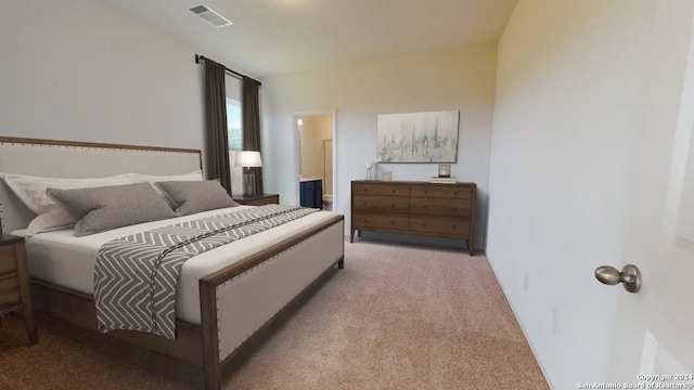 carpeted bedroom featuring ensuite bath and visible vents