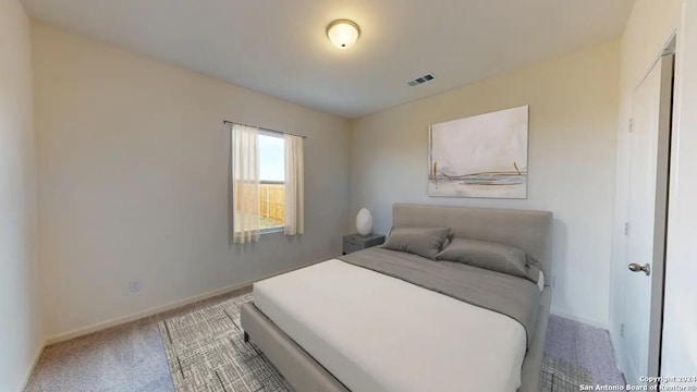 carpeted bedroom featuring visible vents and baseboards