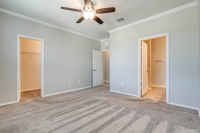 unfurnished bedroom with a spacious closet, carpet, visible vents, and baseboards