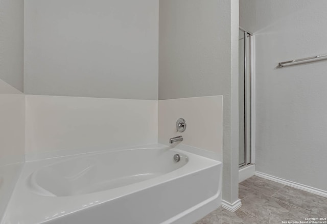 full bathroom featuring a shower with shower door, a bath, and baseboards