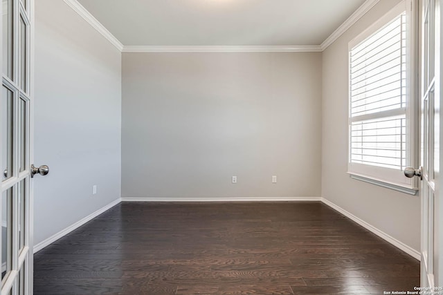 empty room with ornamental molding, dark wood-type flooring, and baseboards