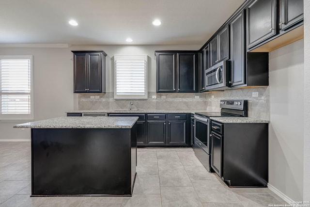 kitchen with light tile patterned floors, plenty of natural light, appliances with stainless steel finishes, and a center island