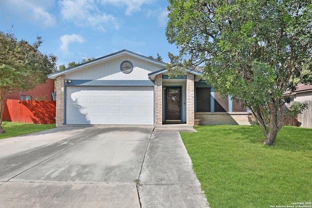 view of front of house featuring a garage, a front yard, brick siding, and fence