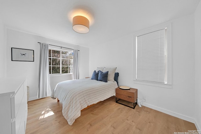 bedroom featuring baseboards and light wood-style floors