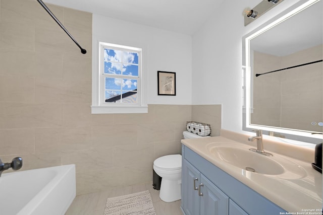 full bathroom featuring bathing tub / shower combination, tile walls, toilet, and vanity