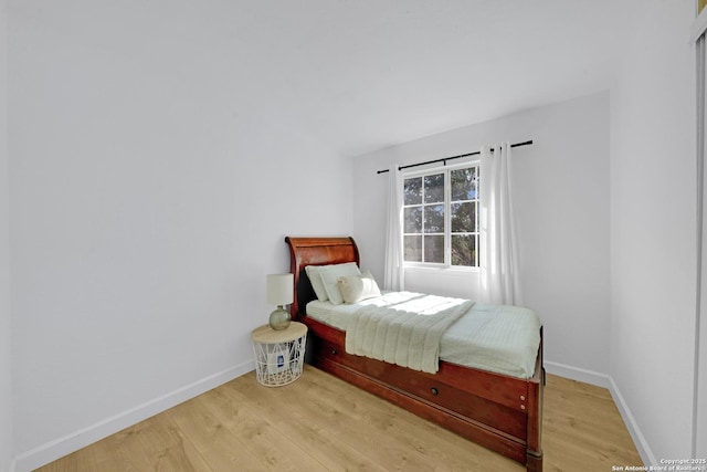 bedroom featuring baseboards and light wood finished floors