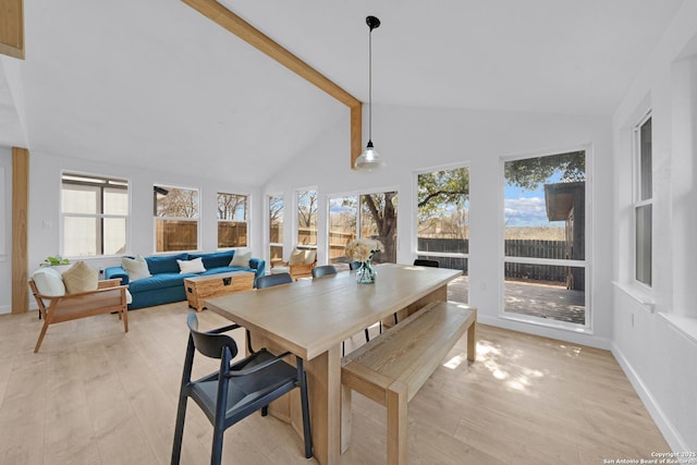 dining area with high vaulted ceiling, beamed ceiling, light wood-style flooring, and baseboards