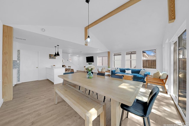 dining room with high vaulted ceiling, beam ceiling, visible vents, and light wood-style flooring