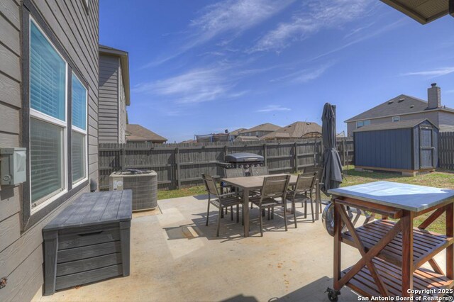 417 Briarfield, Seguin, TX 78155 - view of patio featuring outdoor dining space, central AC, a fenced backyard, a storage shed, and an outdoor structure