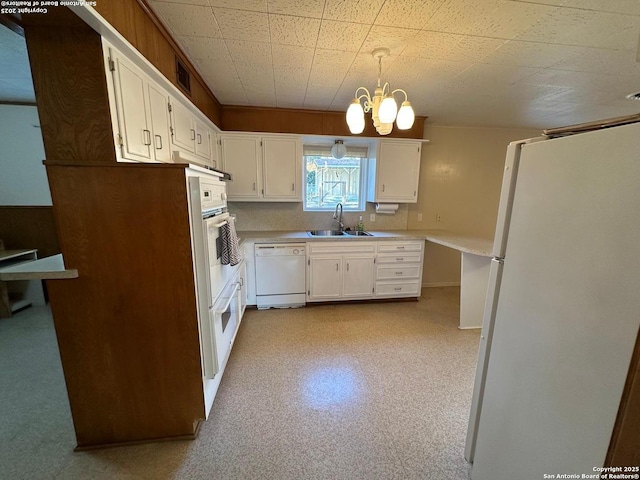 kitchen featuring light floors, light countertops, white cabinets, a sink, and white appliances