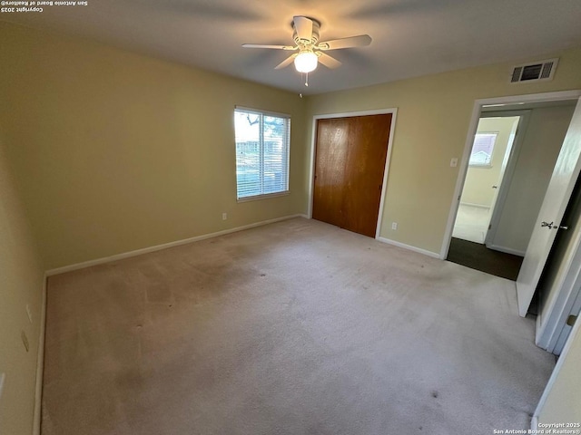 unfurnished bedroom with carpet floors, visible vents, and baseboards