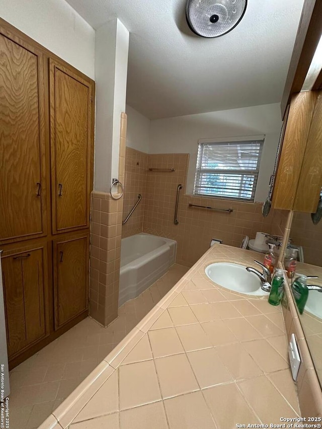 bathroom featuring a washtub, tile walls, tile patterned floors, vanity, and walk in shower