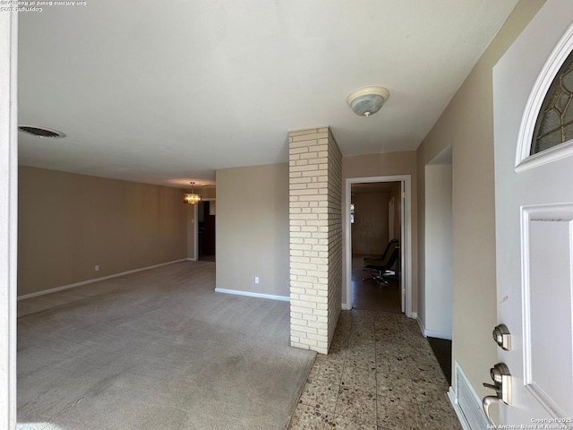 spare room with visible vents, a notable chandelier, and baseboards