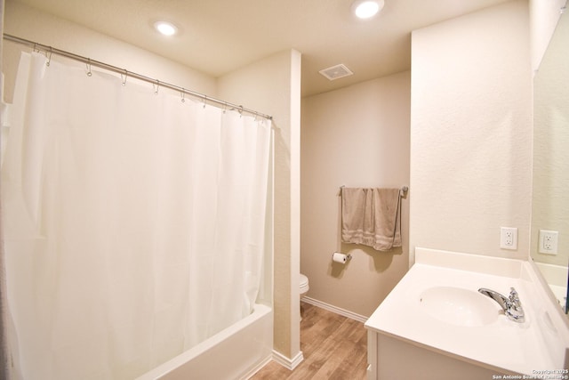 bathroom with visible vents, toilet, wood finished floors, vanity, and recessed lighting