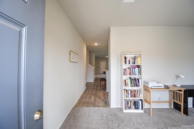 hall featuring carpet and baseboards