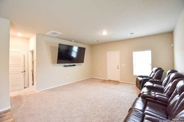 living area featuring baseboards, visible vents, and light colored carpet