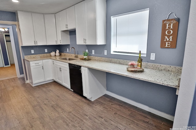 kitchen with black dishwasher, a sink, dark wood finished floors, and white cabinets