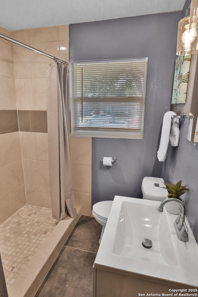 bathroom with a stall shower, tile patterned flooring, vanity, and toilet