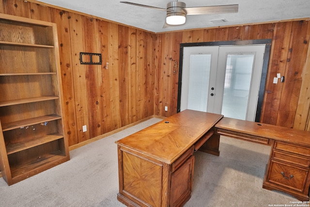 carpeted office featuring visible vents, french doors, a ceiling fan, and wooden walls