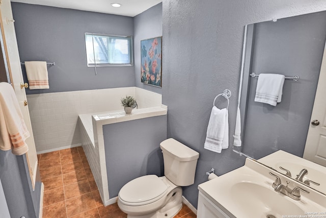 bathroom featuring a textured wall, vanity, toilet, and tile patterned floors