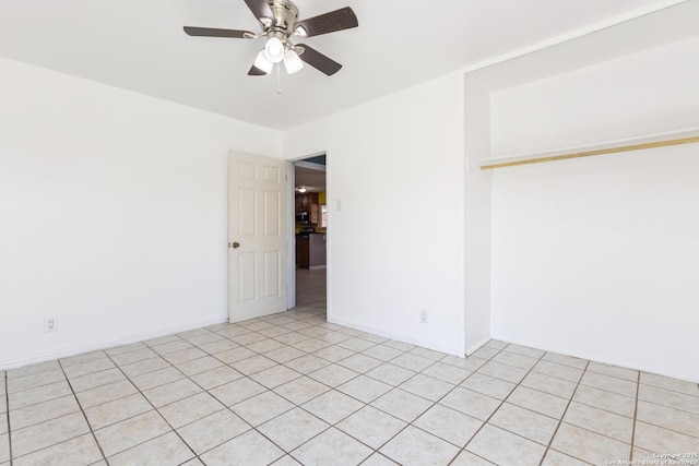 spare room with ceiling fan and baseboards