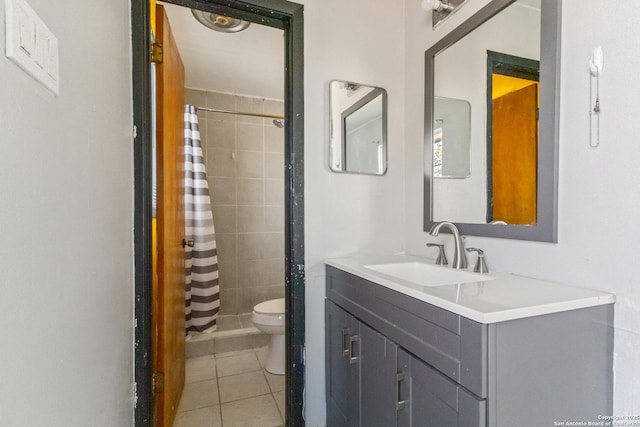 full bathroom with a tile shower, vanity, toilet, and tile patterned floors