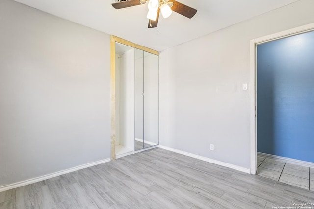 unfurnished bedroom with a ceiling fan, a closet, baseboards, and wood finished floors