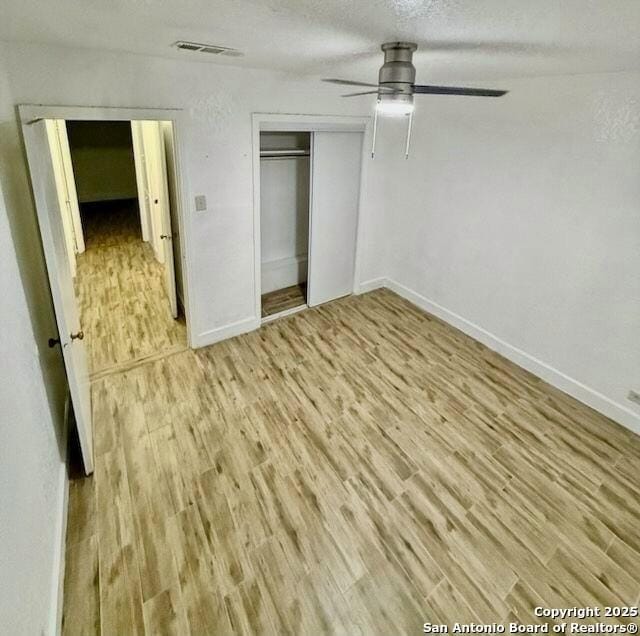 unfurnished bedroom with visible vents, baseboards, a closet, and light wood-type flooring