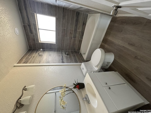 bathroom featuring toilet and a textured wall