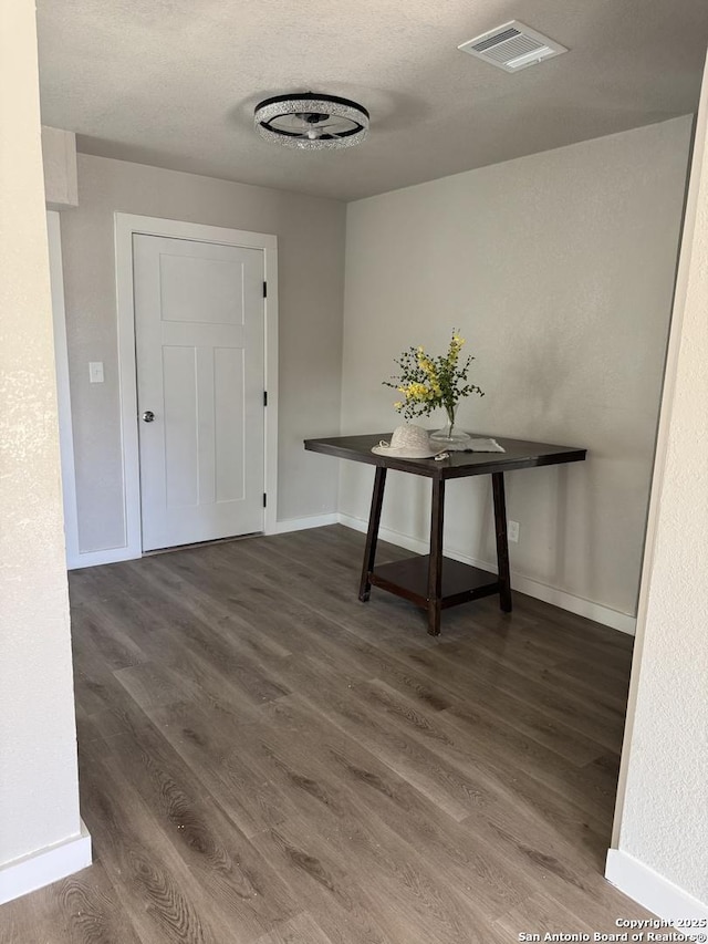 interior space featuring baseboards, visible vents, and wood finished floors