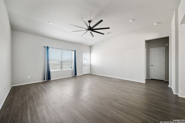 empty room featuring baseboards, visible vents, dark wood finished floors, a ceiling fan, and a textured ceiling