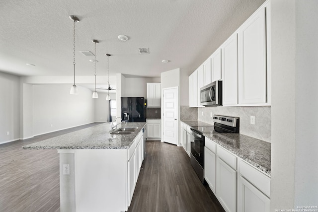 kitchen with tasteful backsplash, visible vents, dark wood finished floors, stainless steel appliances, and a sink