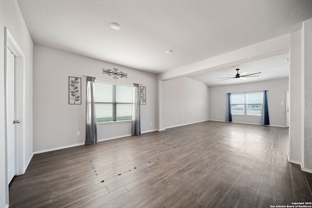 spare room with dark wood-style floors, ceiling fan, a textured ceiling, and baseboards