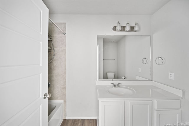 bathroom with  shower combination, vanity, toilet, and wood finished floors