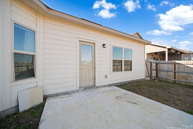 doorway to property featuring fence and a patio