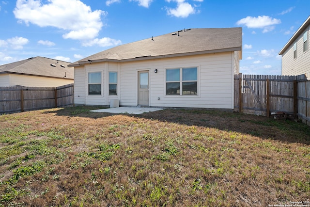 back of property with a patio area, a fenced backyard, and a lawn