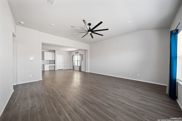 unfurnished living room with baseboards, visible vents, a ceiling fan, dark wood-style floors, and vaulted ceiling