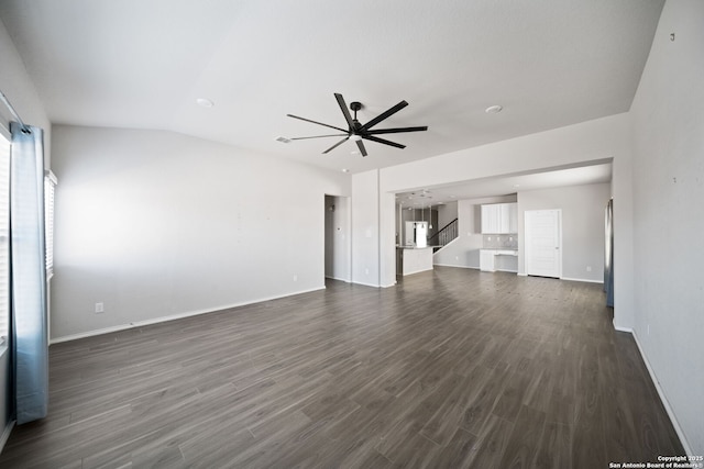 unfurnished living room featuring stairway, dark wood-type flooring, a ceiling fan, vaulted ceiling, and baseboards