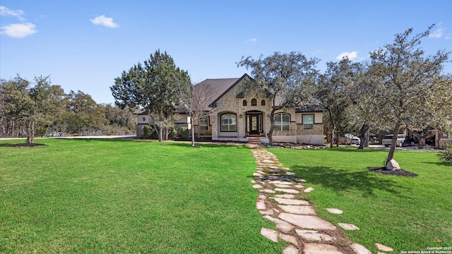 view of front of house with stone siding and a front yard