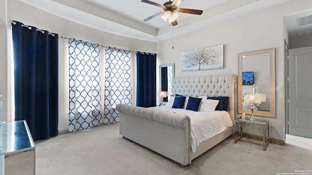 bedroom featuring carpet, a raised ceiling, visible vents, ceiling fan, and baseboards